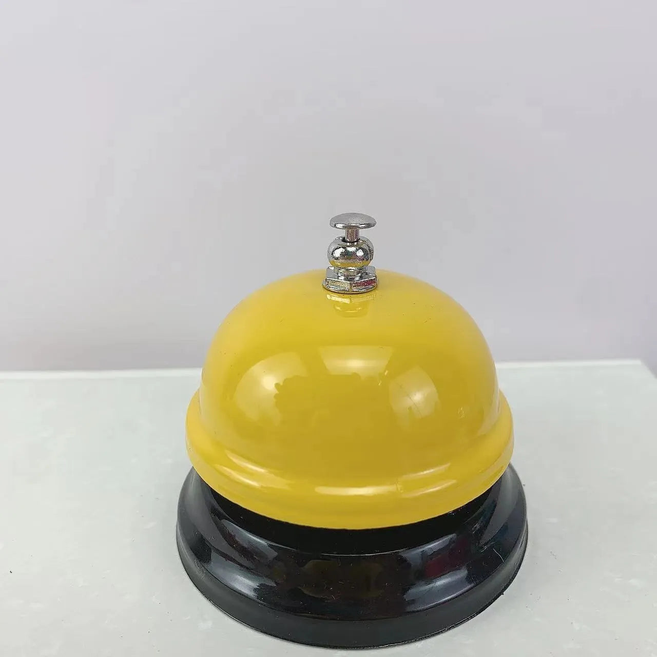 Iron game bell in assorted colours including red, blue, green, pink, and yellow for service or classroom use.