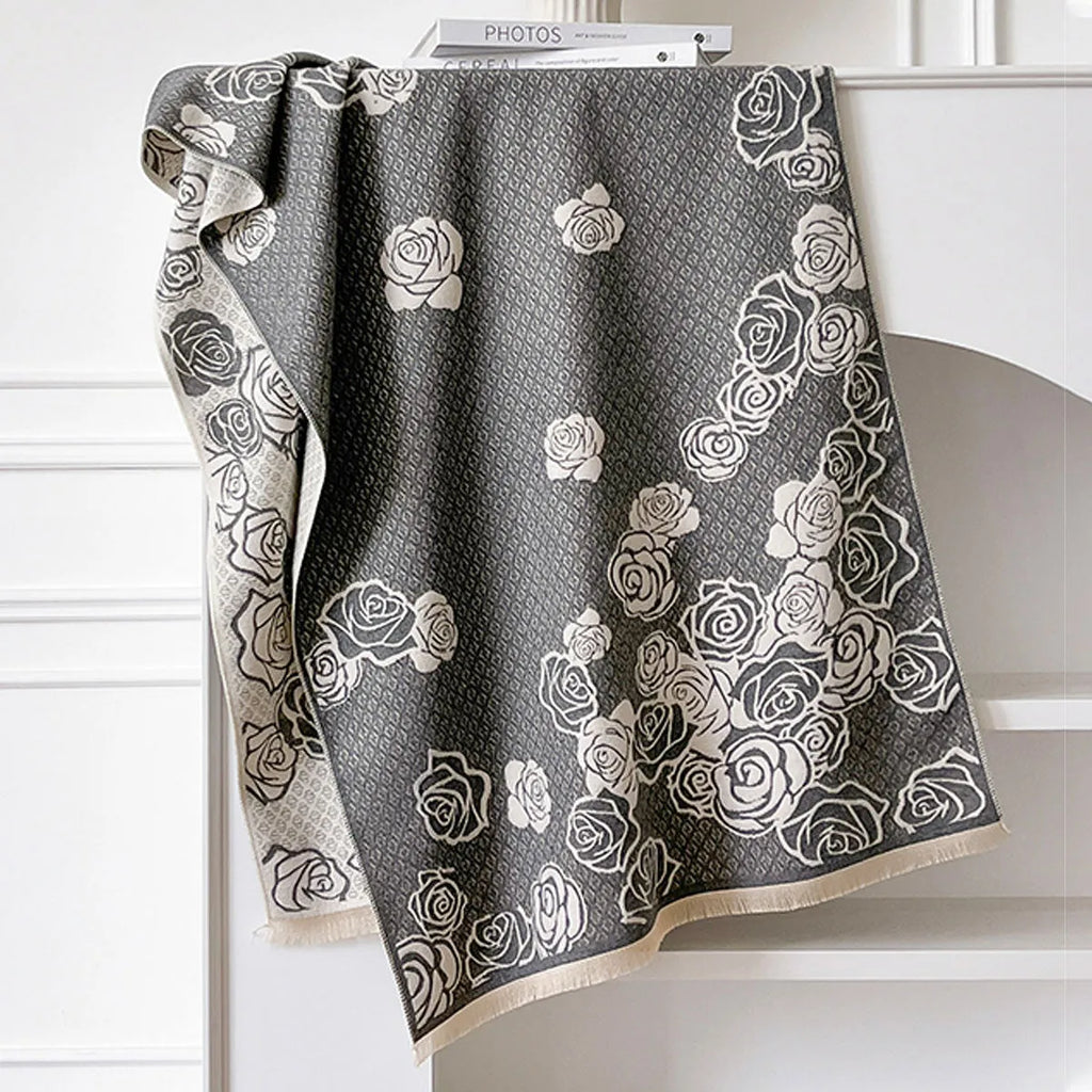 Long grey imitation cashmere winter scarf with tassel fringe on a neutral background.