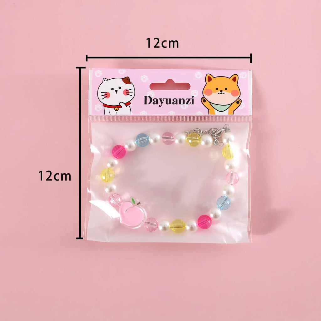 Colourful plastic bead pet necklace in small flower, rainbow, or peach design on an adjustable collar