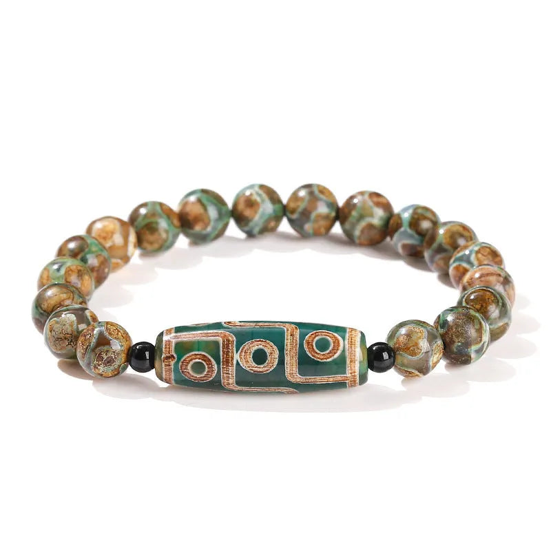 Handmade green dzi bead barrel bracelet with 8mm round geometric beads on a wrist.