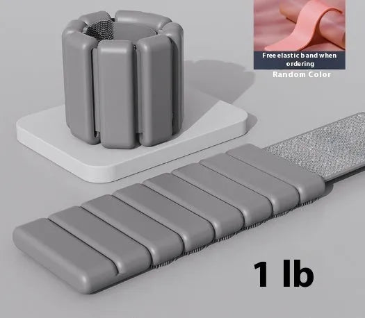 Close-up of a grey detachable weighted fitness bracelet with Velcro strap on a wrist.