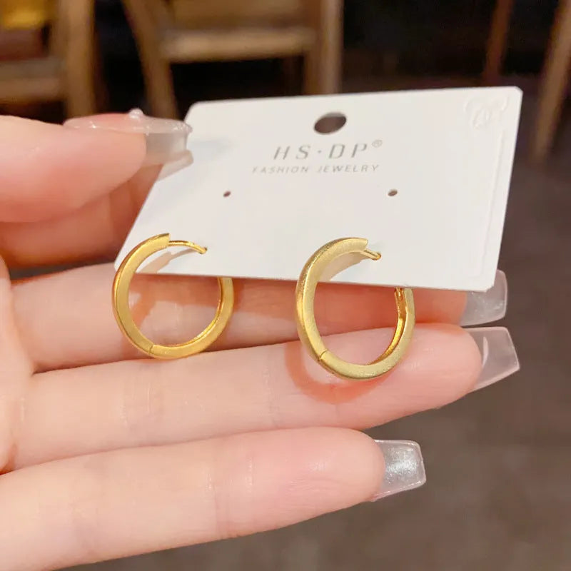 Geometric round women's ear clip with eyelet detail in gold or silver finish