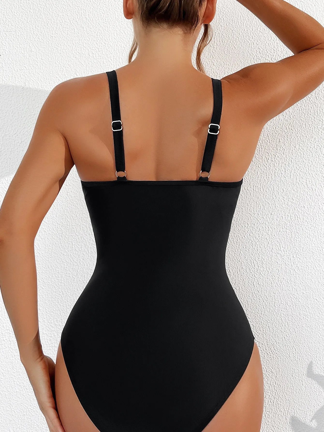 Black halter neck one-piece swimsuit with bikini style briefs, made from nylon fabric.