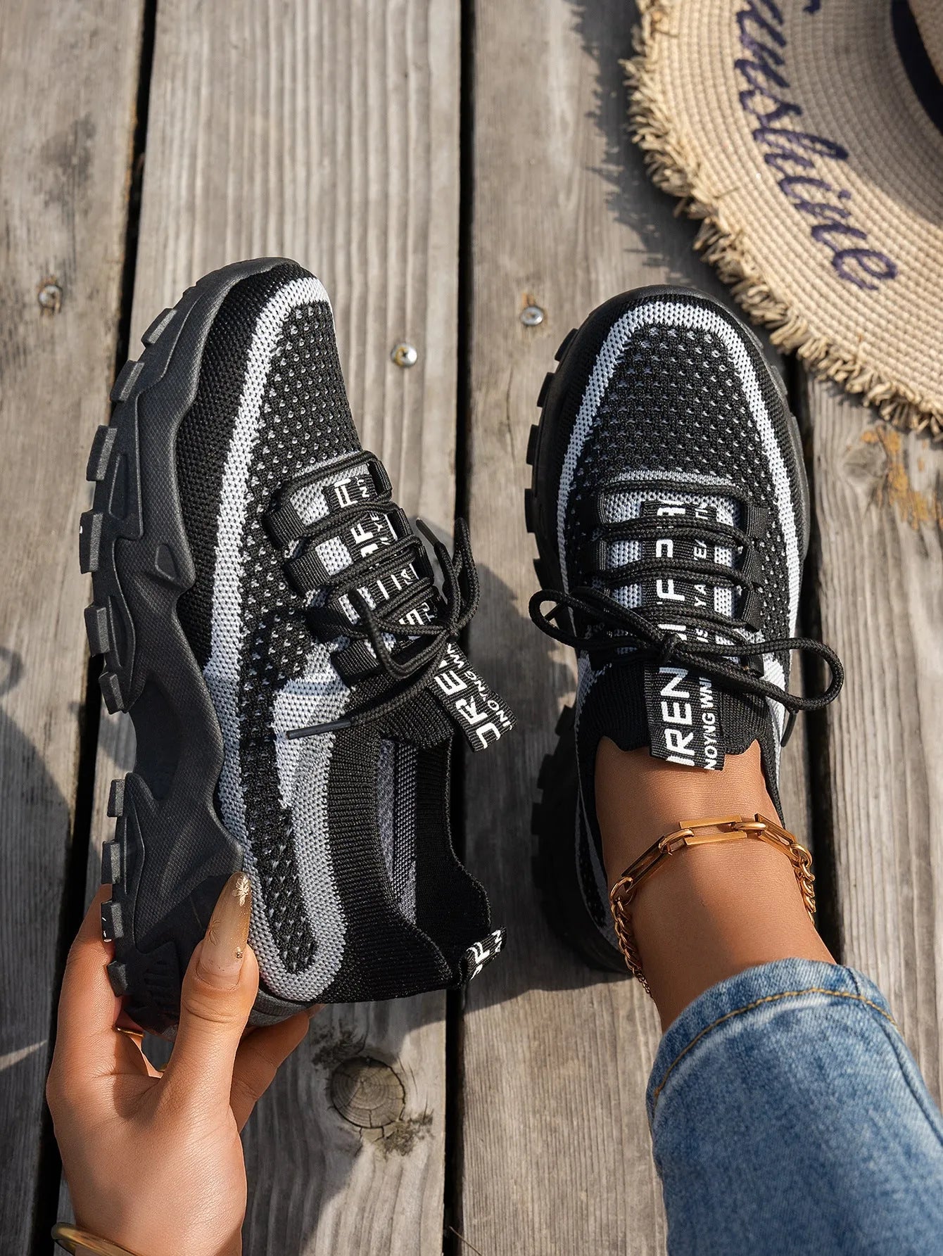 Women's Flyknit mesh lace-up sneakers in grey and white with a low rubber sole.