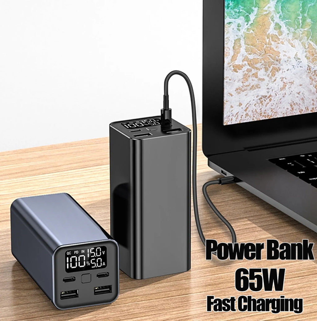 Black metal 65W laptop power bank with 20000mAh capacity showing size next to a laptop.