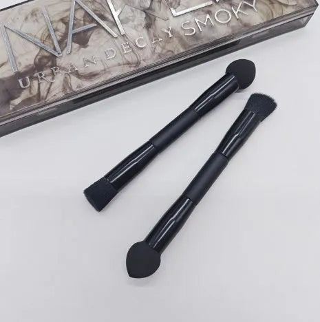 Double-headed concealer brush with black wooden handle, artificial fibre bristles, and angled sponge tip.