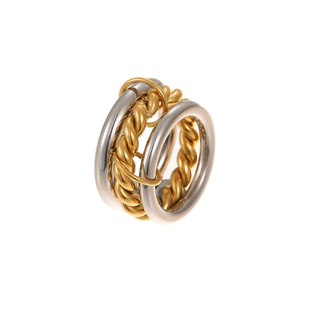 Stacked gold plated stainless steel rings with an exaggerated design on a person's hand.