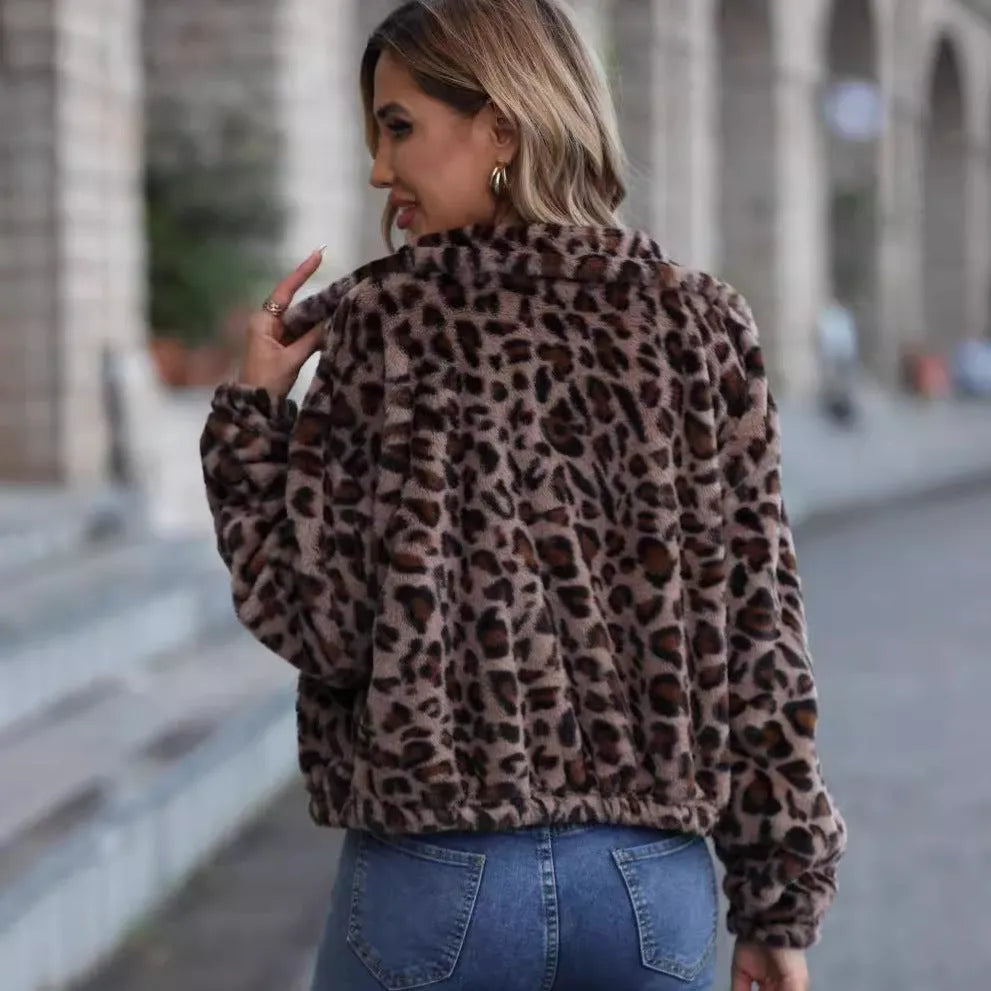 A woman's loose-fitting, zip-front plush coat in a leopard print pattern with raglan sleeves.
