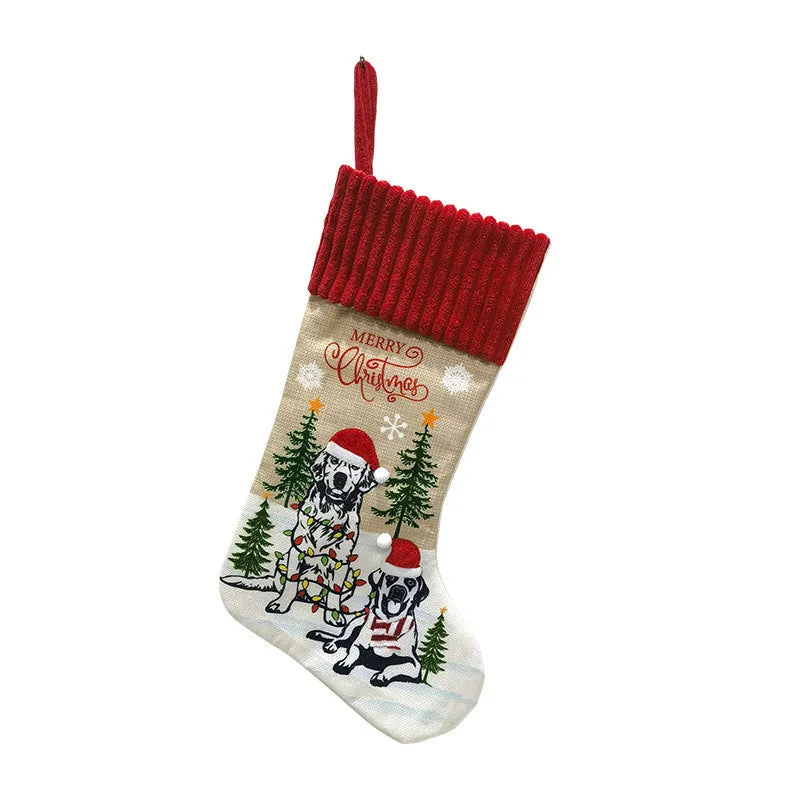 Red and green cloth Christmas stocking pendant for pets, hanging on a tree branch.