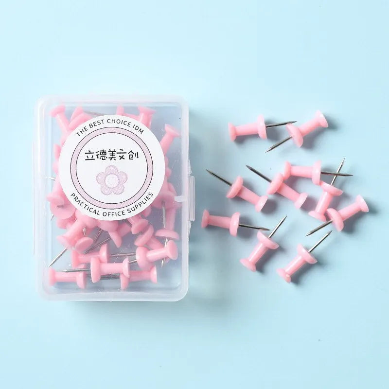 Plastic push pins in cherry blossom pink, mint green, and lavender colours, showing both large and small sizes on a white surface