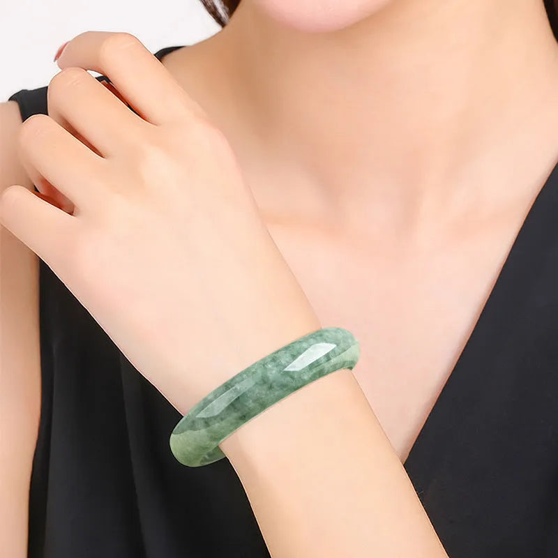Natural deep pea green jade bangle bracelet for women on a gift box.
