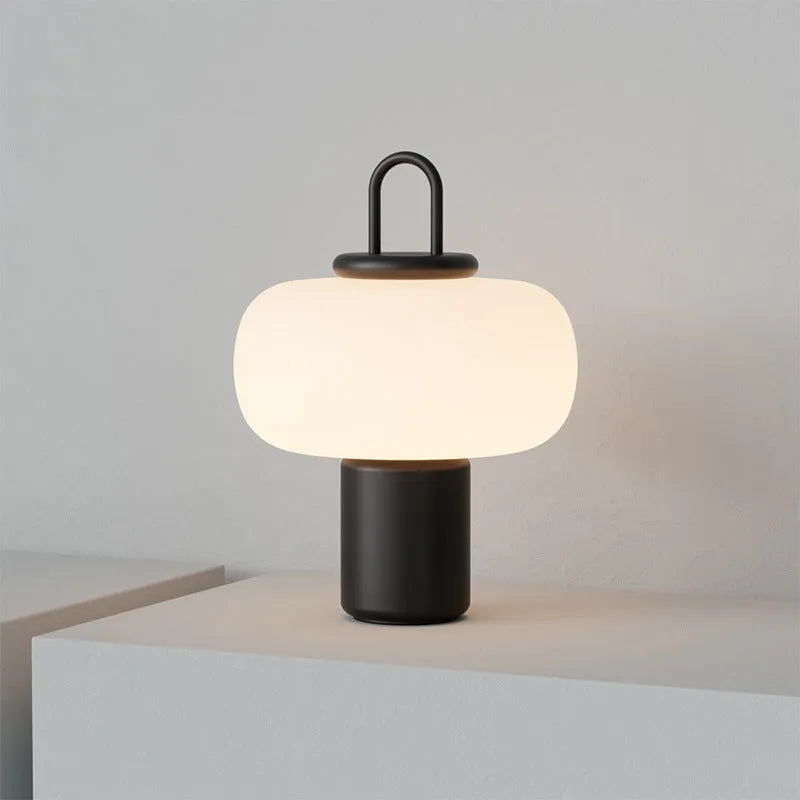 Minimalist Japanese designer glass bedside table lamp with warm light for a child's room.