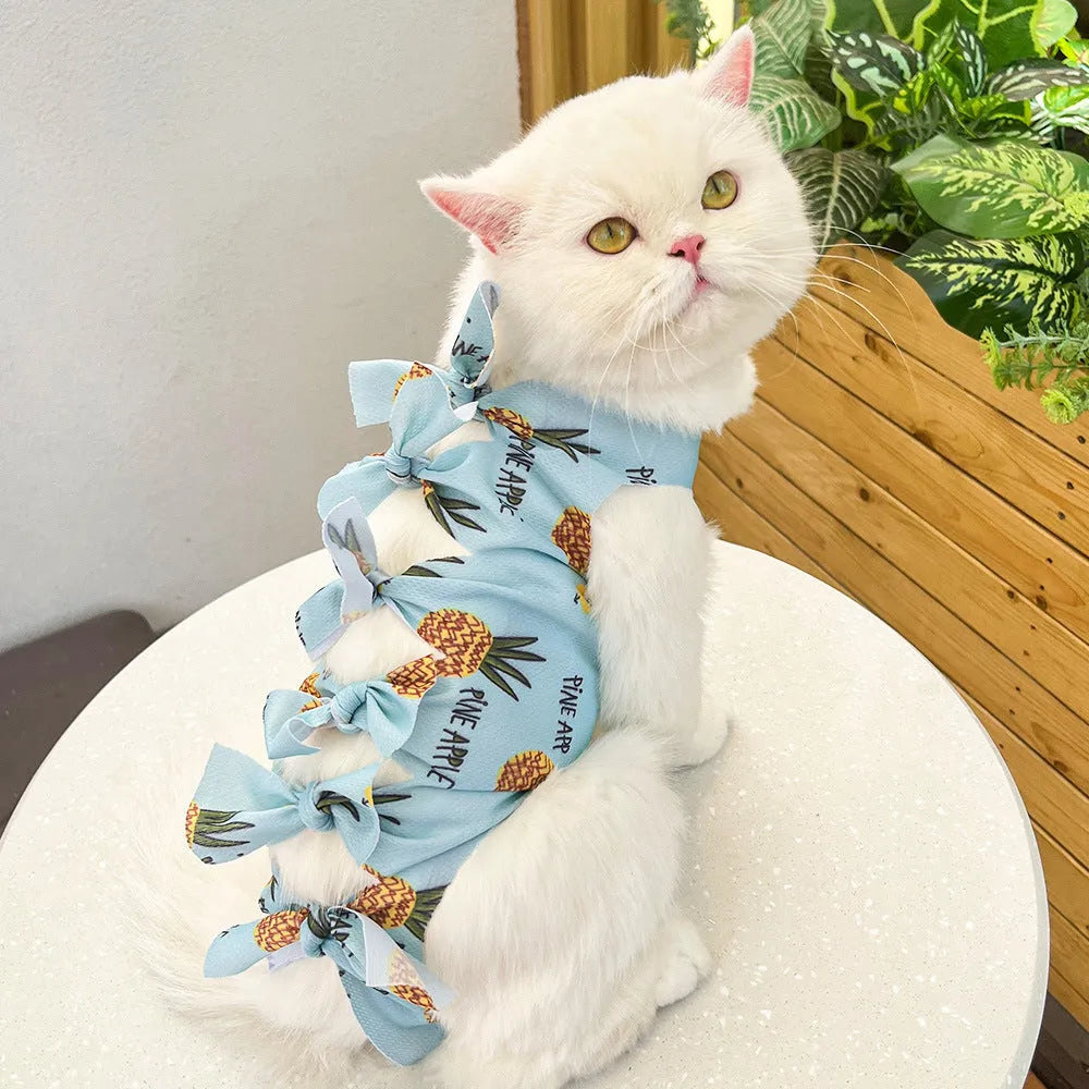 Pink lace-up cat recovery bodysuit on a table, showing back ties and full-body design for post-surgery care.