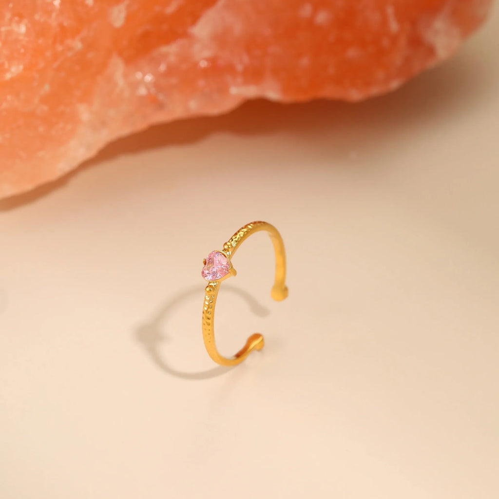 Geometric open-ended heart-shaped stainless steel ring with inlaid zircon detail in white, pink, or green.