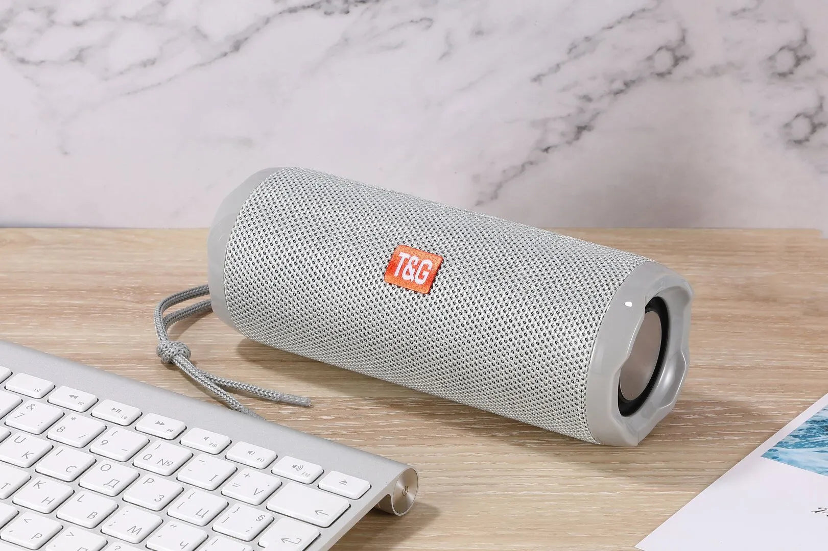 Fabric-covered portable Bluetooth speaker showing the integrated card holder slot, displayed in the camouflage colour variant.