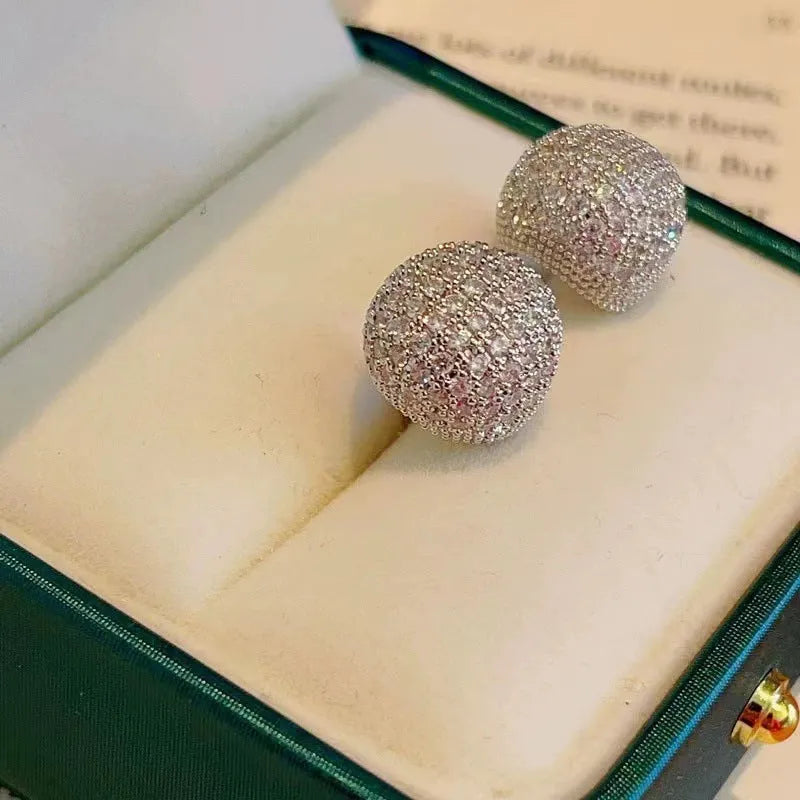 Geometric drop-shaped ear clips with spherical elements in gold and white colour options