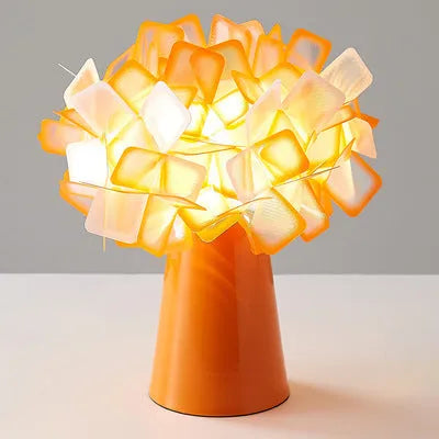 Nordic style decorative table lamp in a choice of colours including black, blue, and orange on a wooden surface.