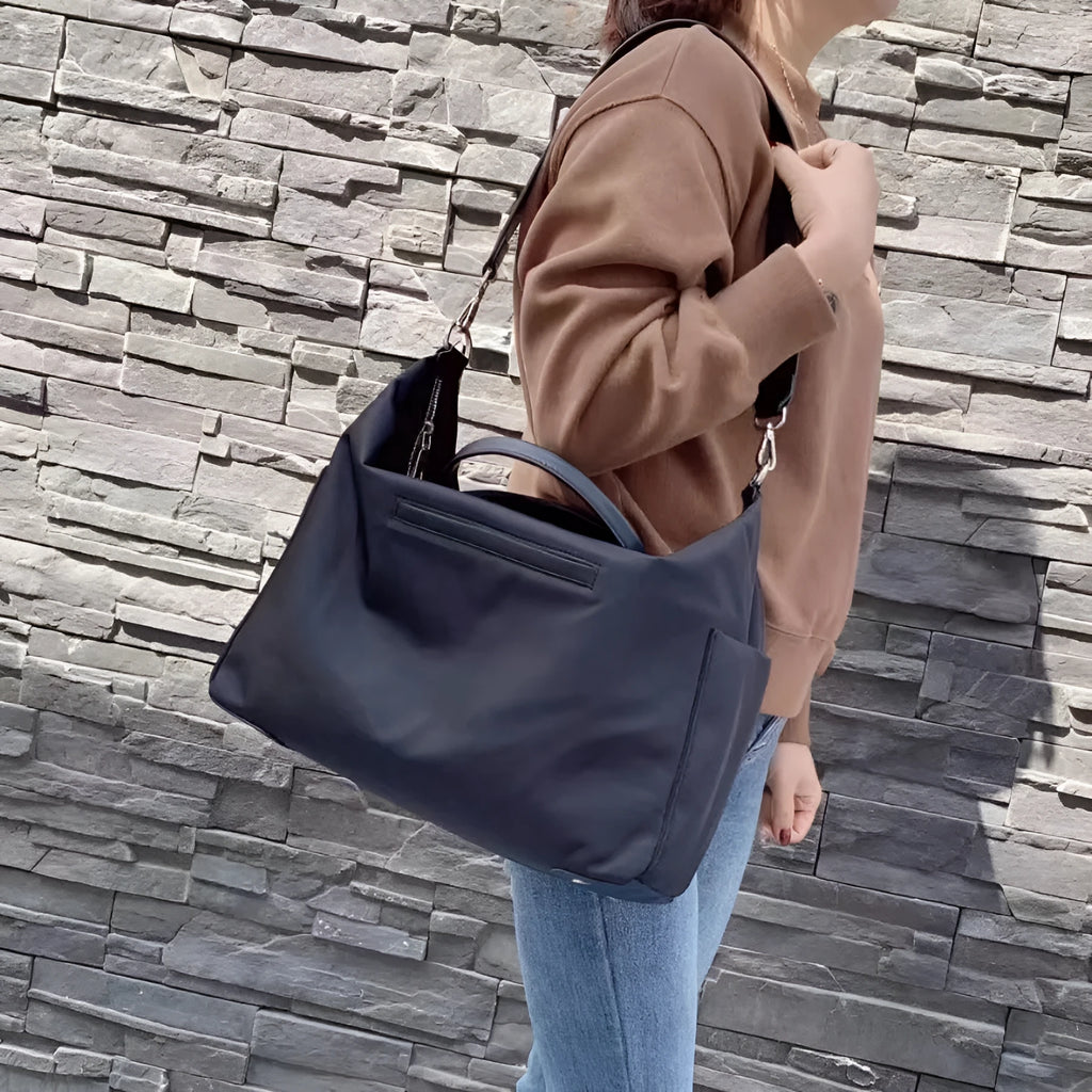 Black waterproof nylon simple shoulder bag with shoulder strap, shown next to light khaki colour option.