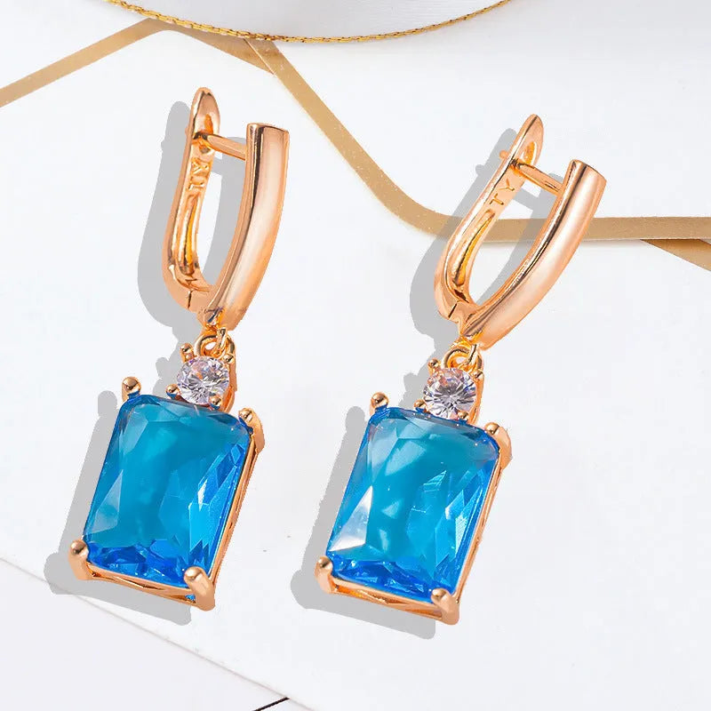 A pair of square gold or silver electroplated copper earrings with geometric design.