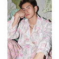 Women's pink embossed floral long sleeve loose-fit shirt on a hanger.