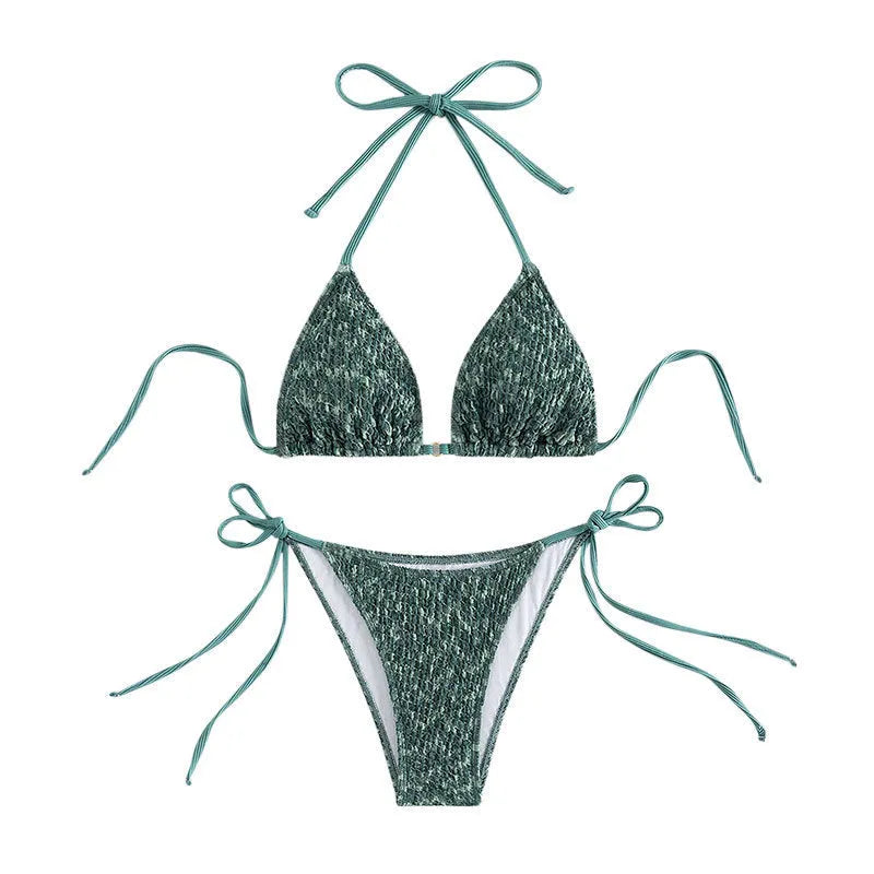 Green backless women's bikini with halter neck strap lying flat.