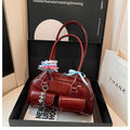 Retro-style brown PU leather women's pillow handbag with a one-shoulder strap, shown with a decorative ribbon pendant.