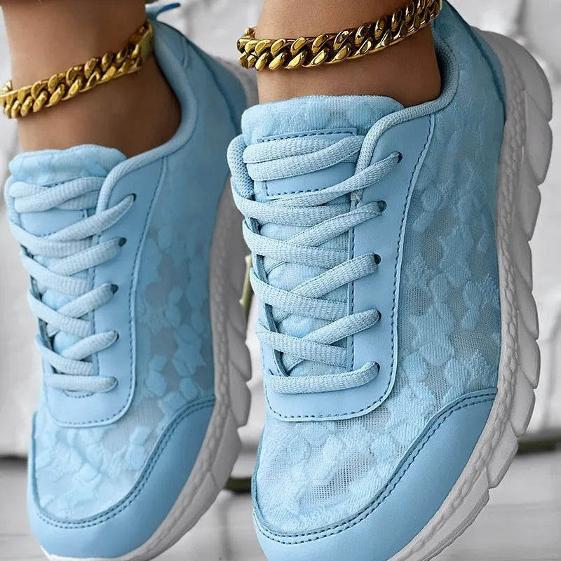 Women's white canvas running shoes with a soft flat sole on a plain background.
