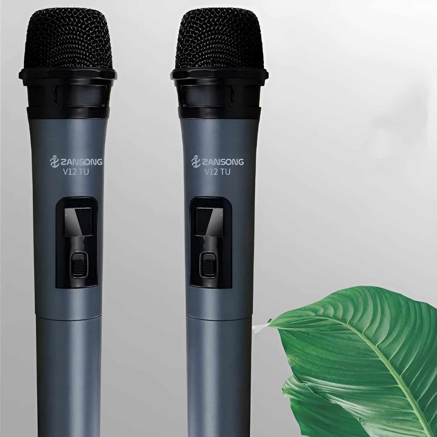 Black handheld dynamic microphone with USB receiver and cables on a table.
