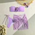 Women's pink swimsuit set with floral tie tube top, matching bottoms, and detachable skirt laid flat.