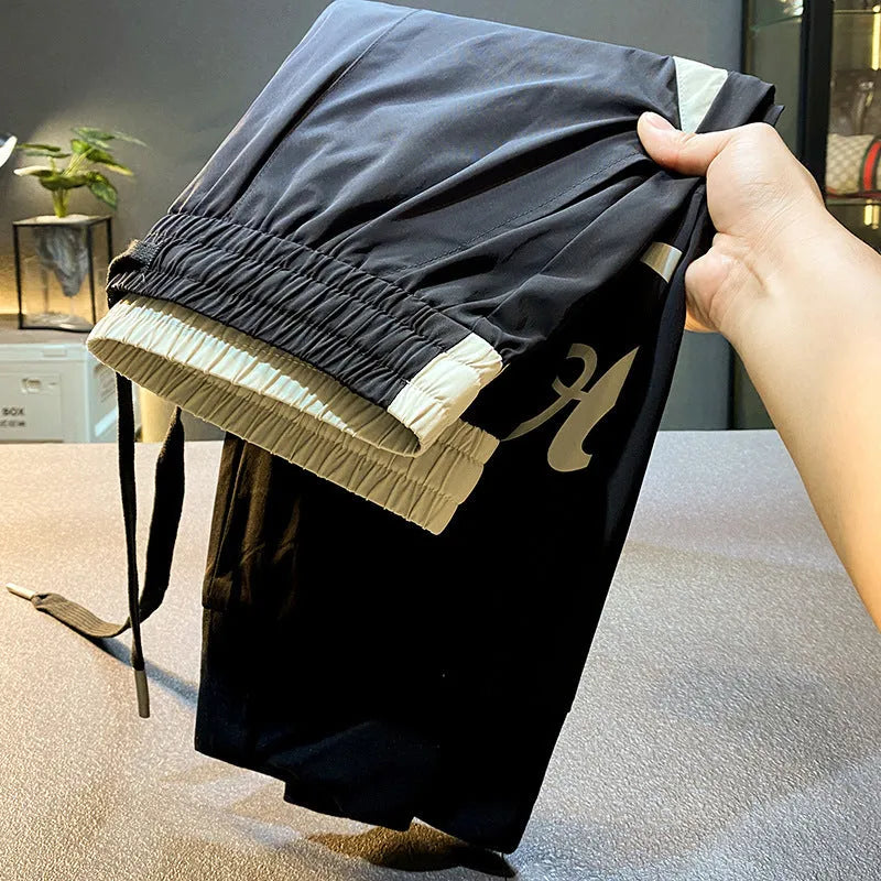 Men's black ankle band trousers with cropped casual fit in lightweight ice silk cotton fabric