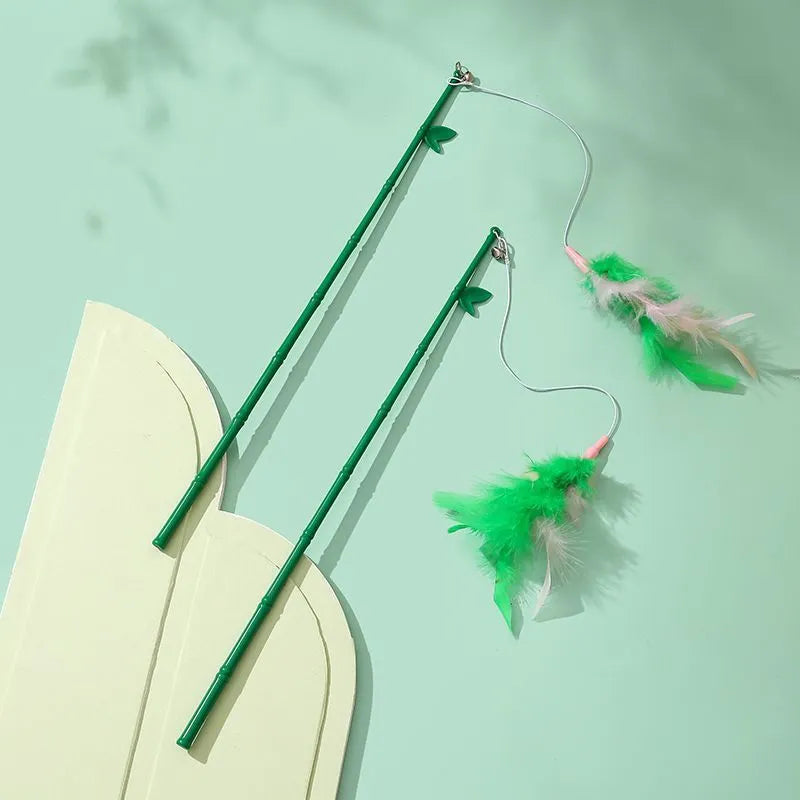 Green interactive cat feather wand toy with bell attachment on a durable stick