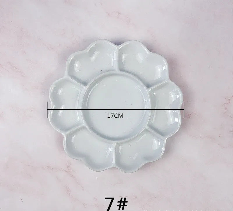 White hand-made ceramic plum blossom shaped artist palette for paint mixing.