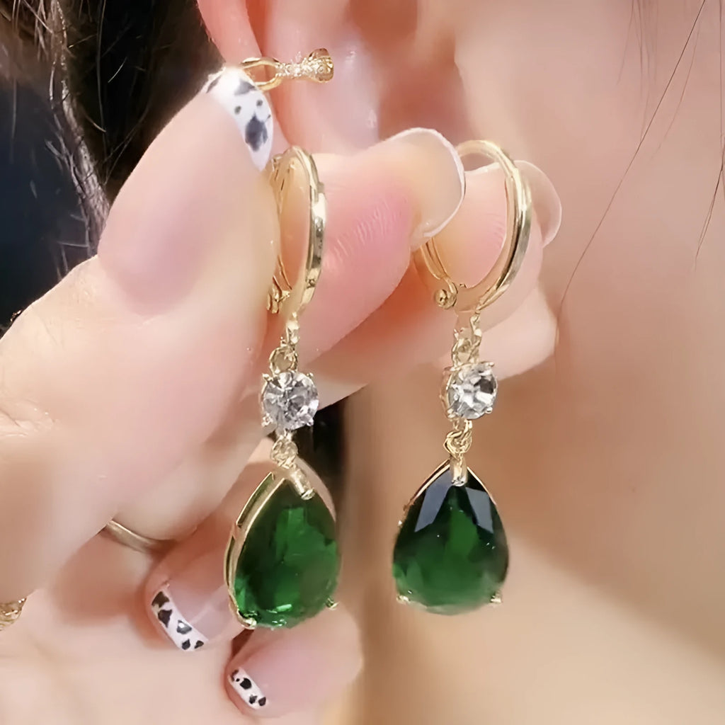 A pair of emerald green geometric teardrop alloy earrings on a plain background.