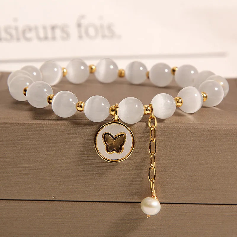 White cat's eye crystal bracelet with geometric design on a wrist