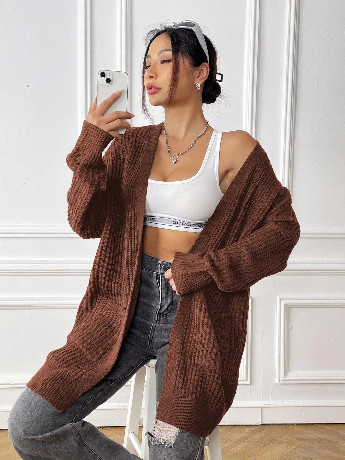 Dark green loose women's cardigan with two pockets and long sleeves.