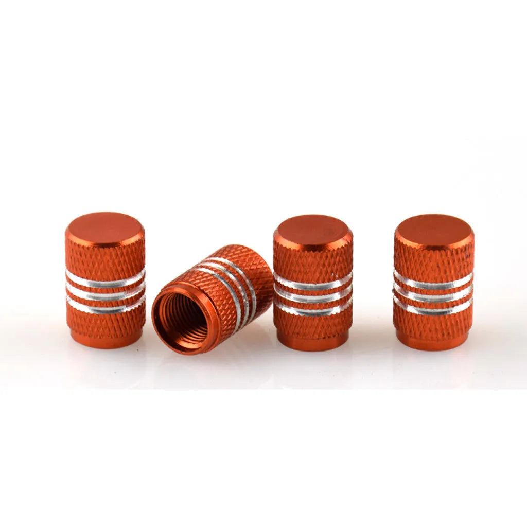 Assortment of aluminium alloy car tyre valve caps in ten different colours on a grey background.