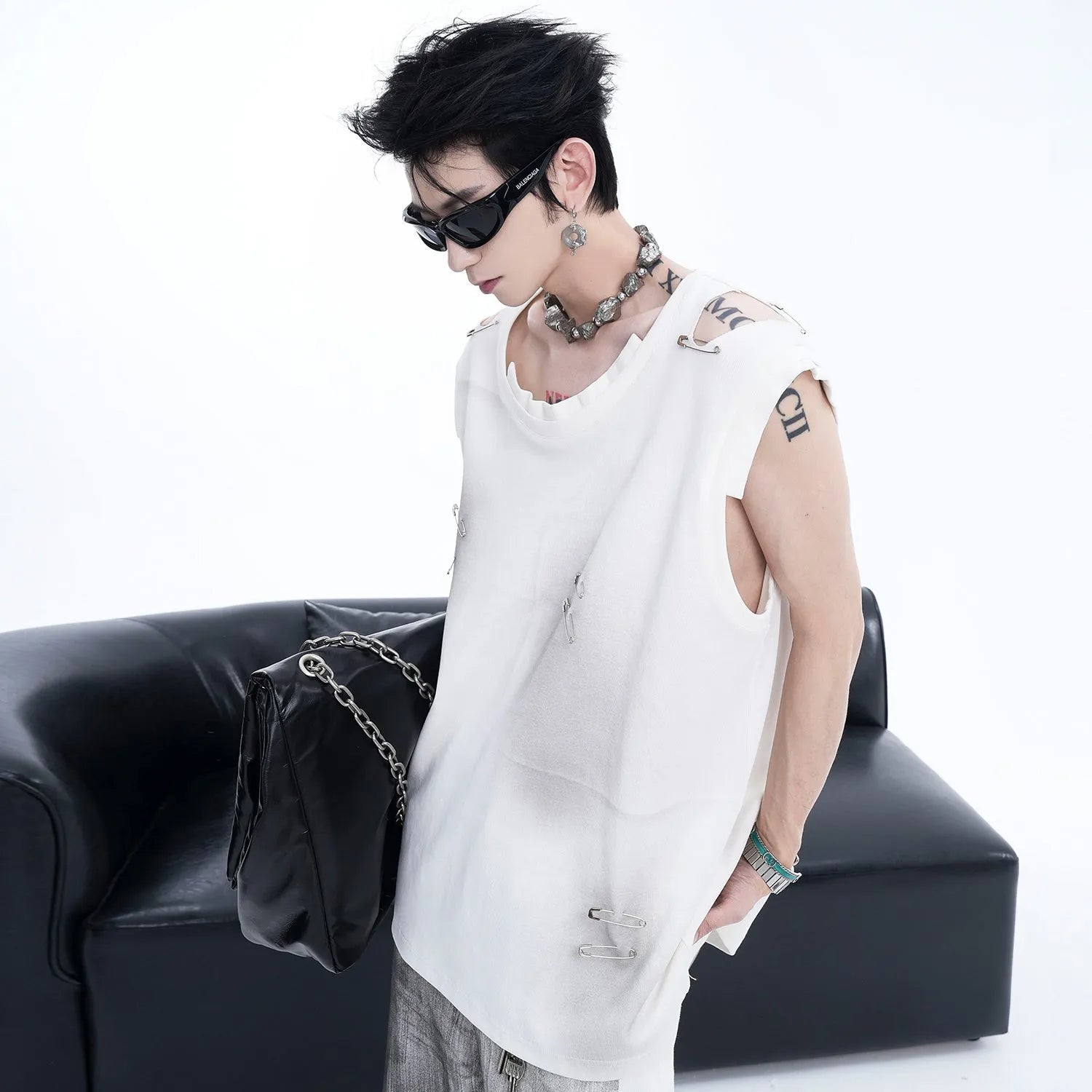 Men's black distressed waistcoat vest with asymmetrical cut on a hanger.