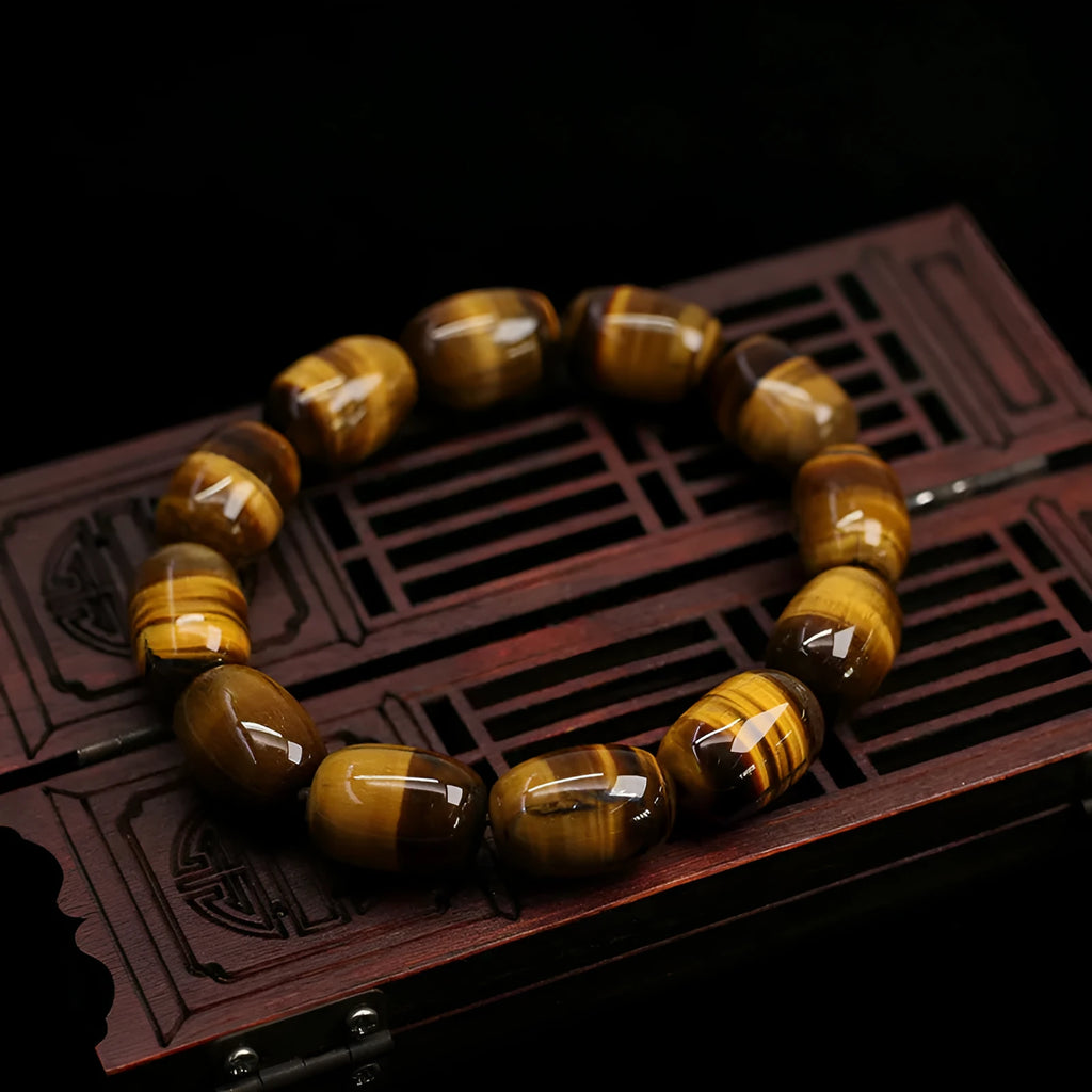 Natural yellow tigereye gemstone bracelet with ethnic constellation design on a wrist.