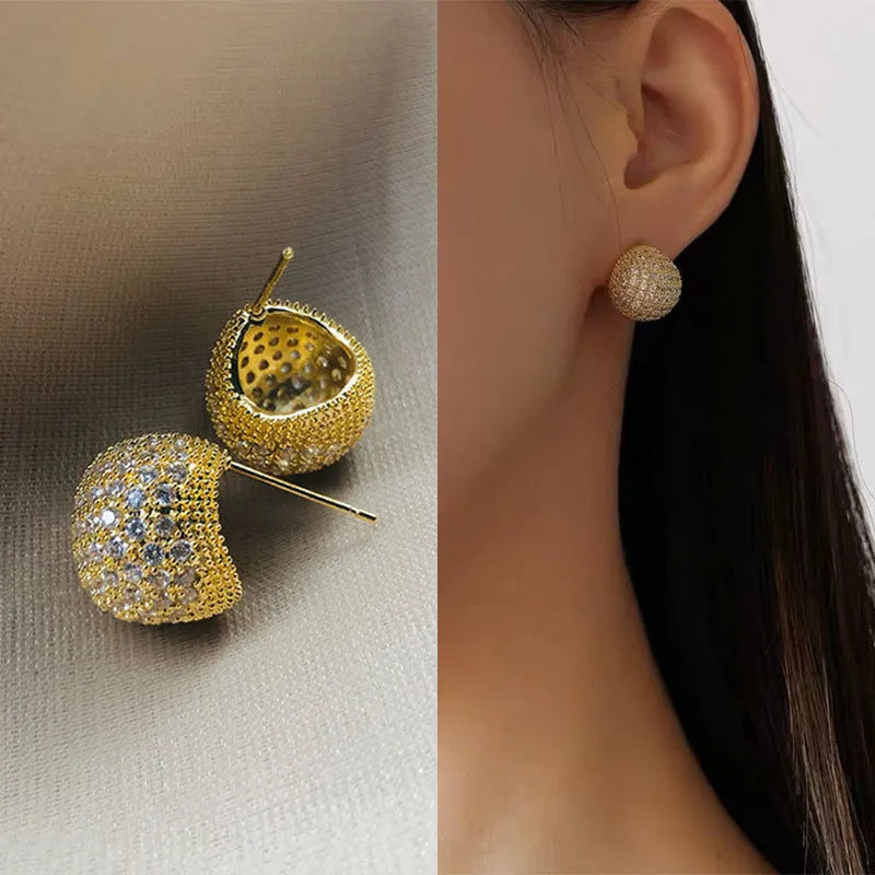 Geometric drop-shaped ear clips with spherical elements in gold and white colour options