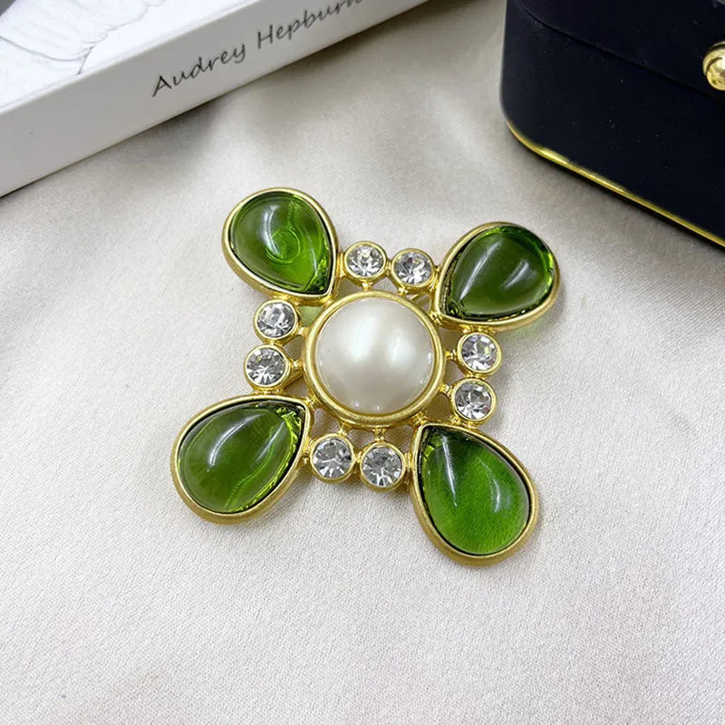 Close-up of a vintage medieval baroque cross brooch in zinc alloy with crystal accents, showing intricate detail.