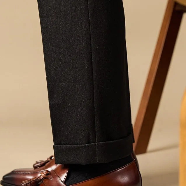 Men's black and brown polished leather tassel loafers for business casual wear, shown from the side.