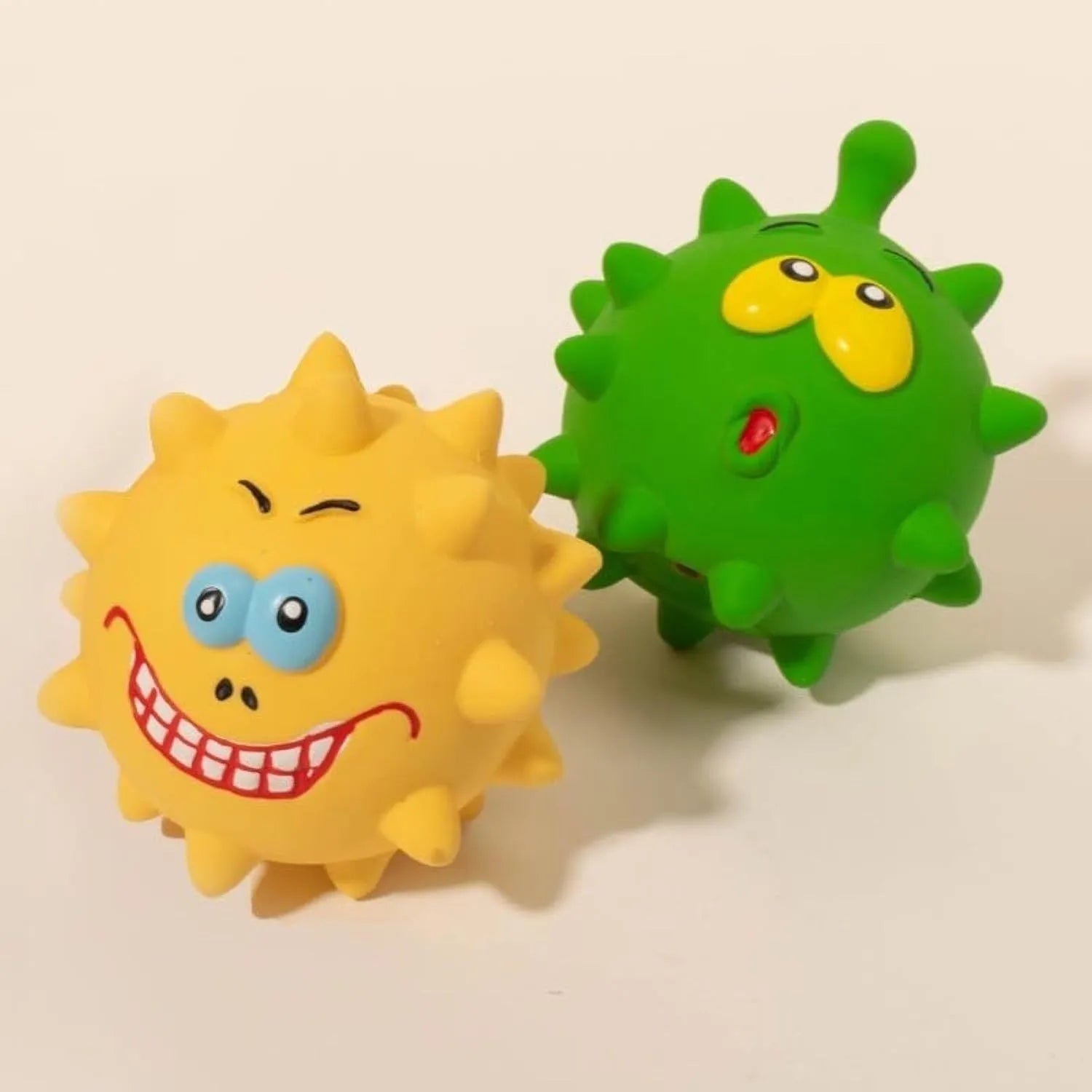 Set of four coloured squeaky dog balls with cute faces, made from natural latex rubber.