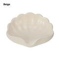White or pink plastic shell-shaped soap dish for bathroom sink or shower.