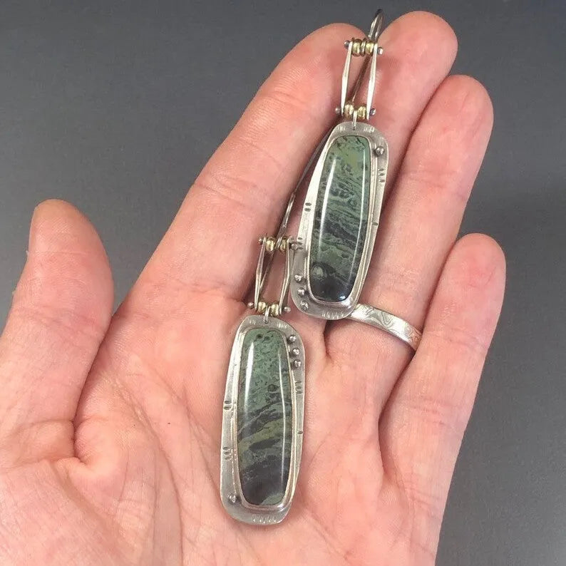 Geometric drop earrings with a white and grey marble pattern on a silver-toned alloy setting.