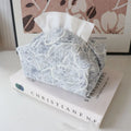 Chinese style floral cotton tissue box cover in beige, blue, and brown on a wooden table.