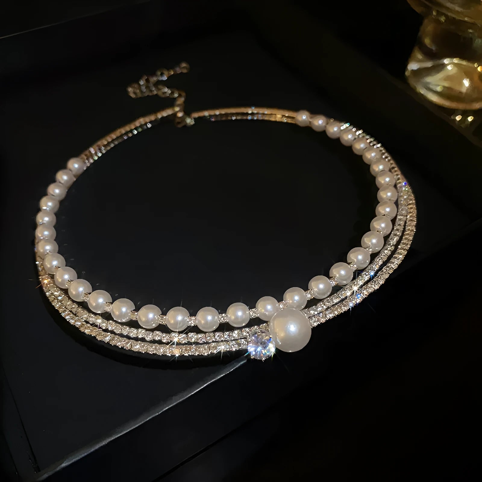 Silver curved round necklace lying flat, showing its geometric shape and clavicle chain design.