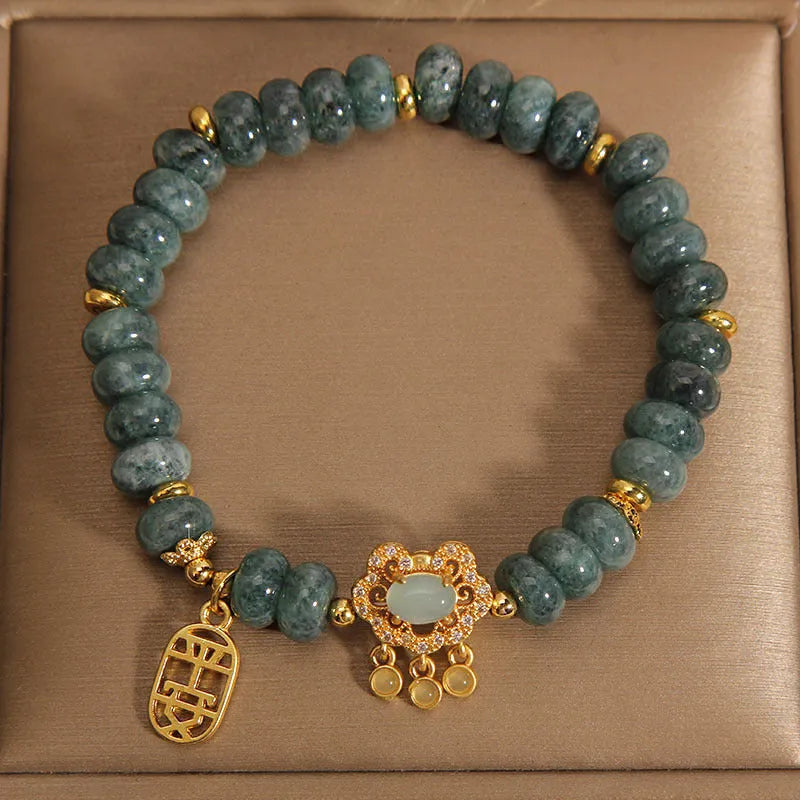 Close-up of a women's bracelet with green emerald jade and silver alloy abacus beads and a safety lock clasp.
