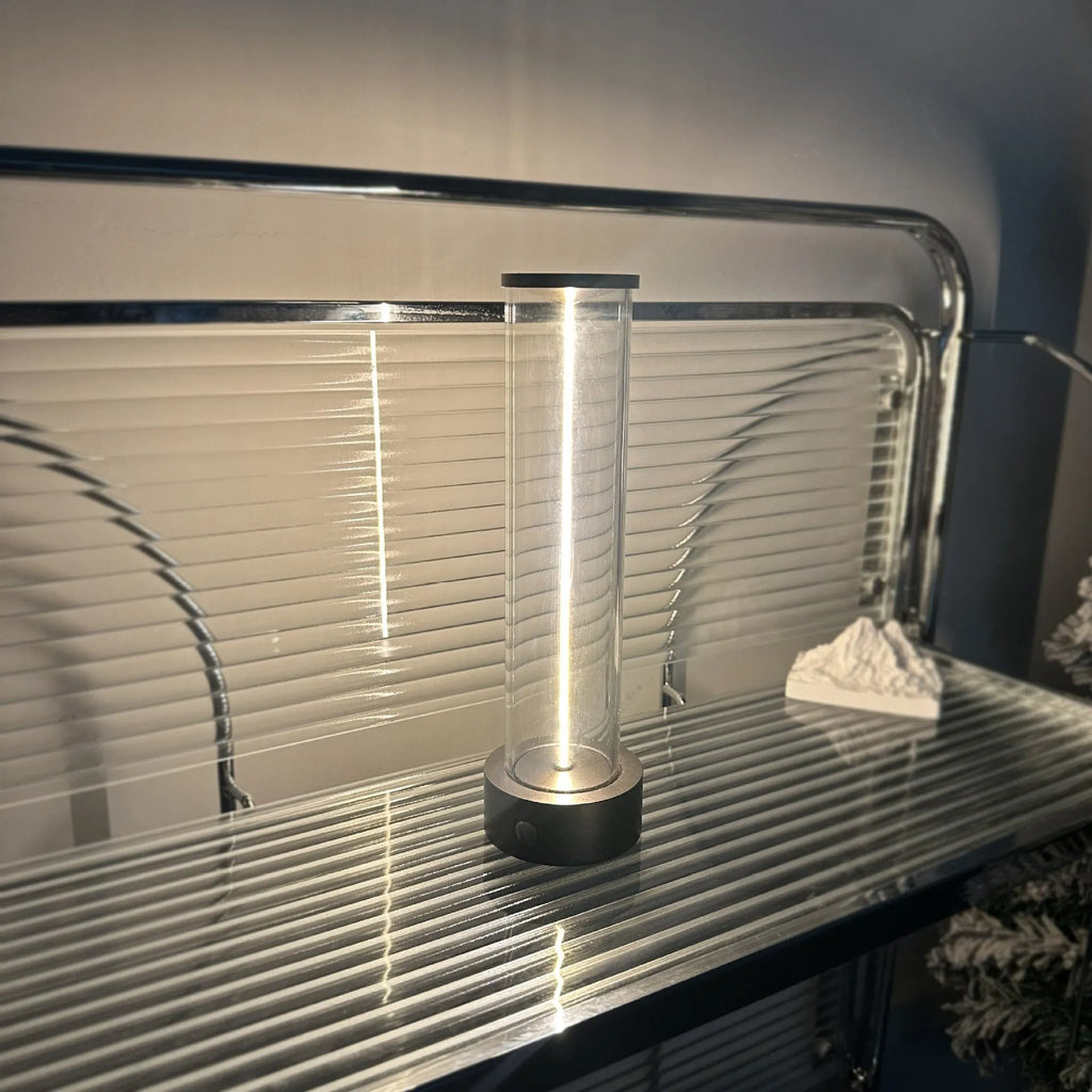 Modern glass USB LED night light with magnetic strip on a metal surface.