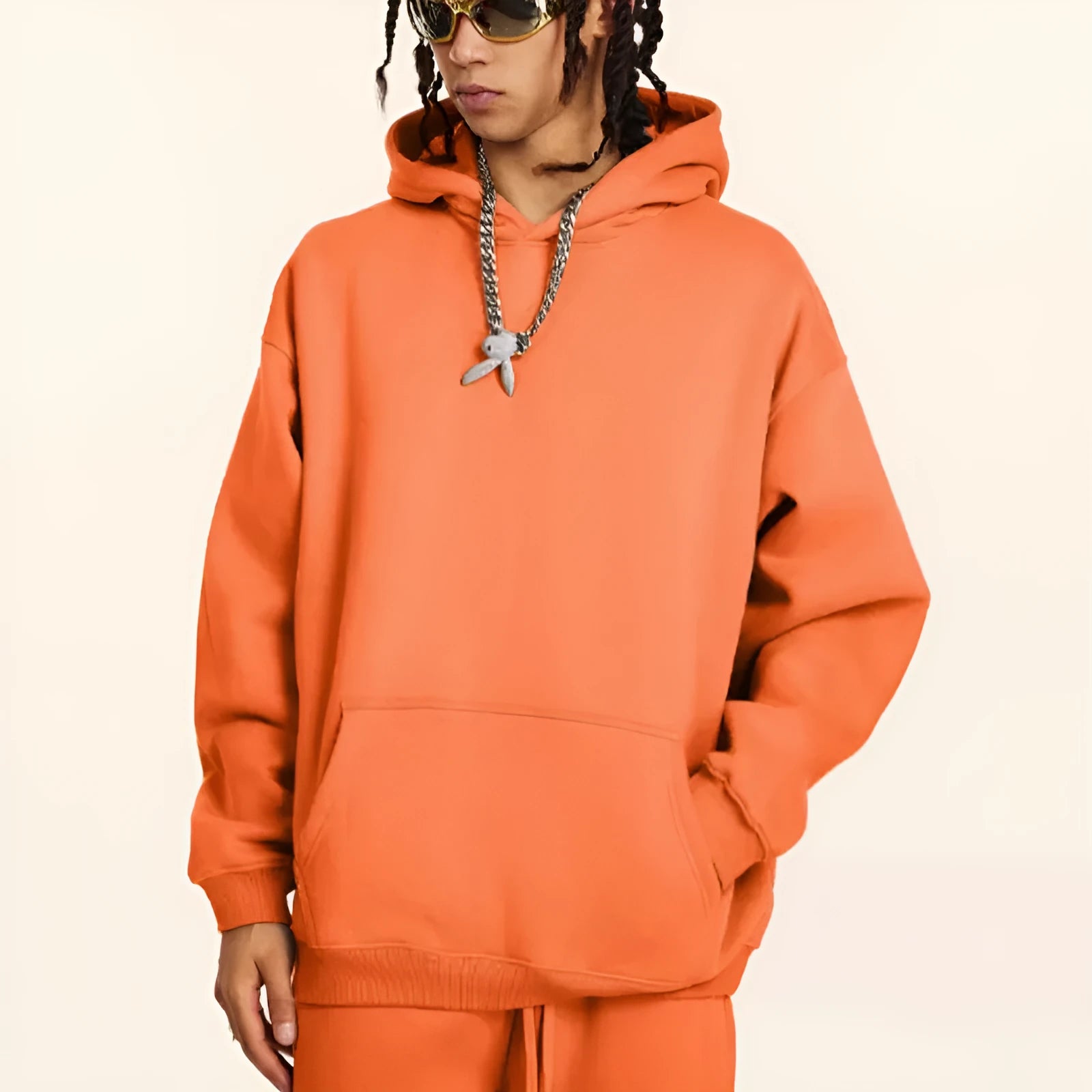 A loose-fitting men's cotton hooded sweater in a pullover style on a hanger.