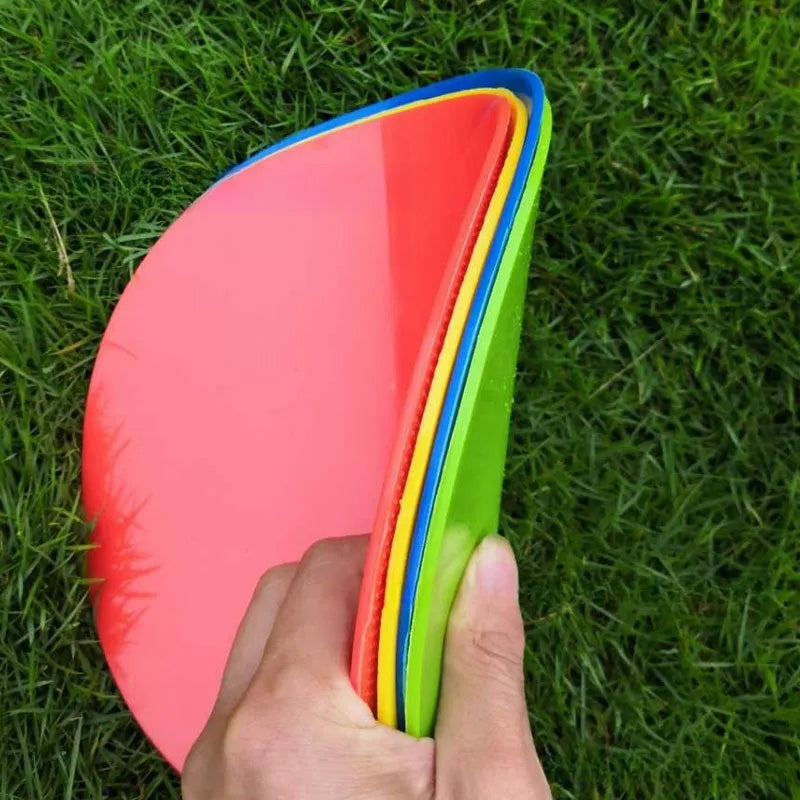 Yellow football training marker disc on grass field showing 23cm diameter flat design